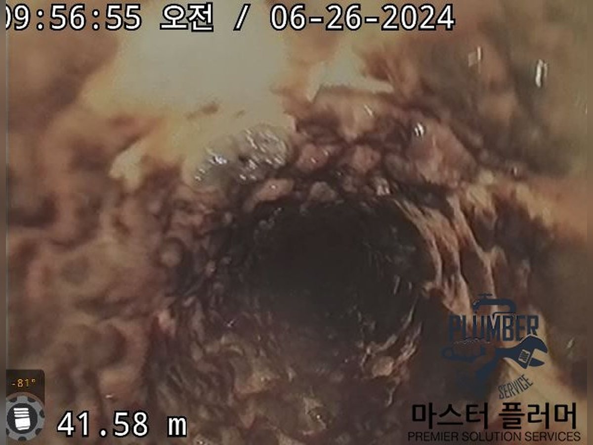 세척 전 오물로 관 단면이 좁아진 입상관 내부 내시경 화면